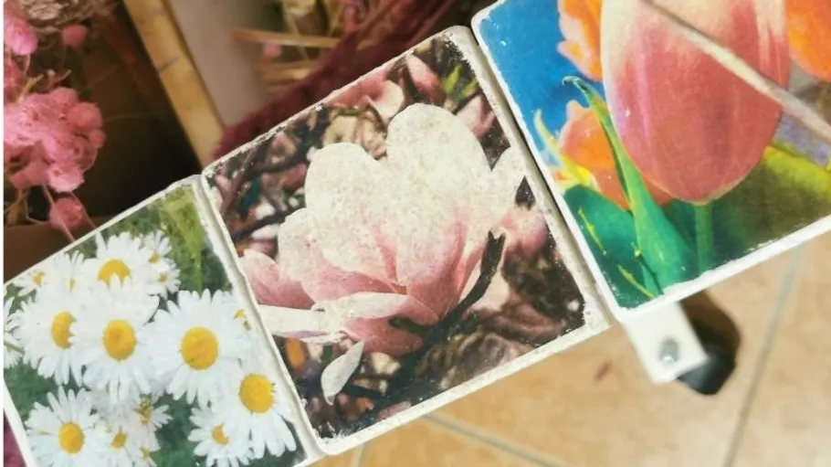 Three tiles with floral images on display.