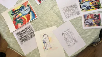 Bunte Pferdezeichnungen und Skizzen auf einem Tisch.