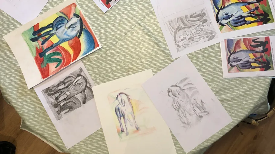 Colorful horse drawings and sketches on a table.