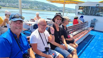 Four people smiling on a boat deck.