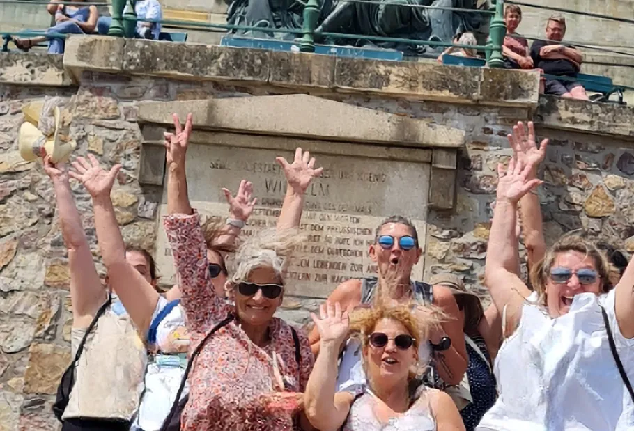 Group posing happily by historical monument.