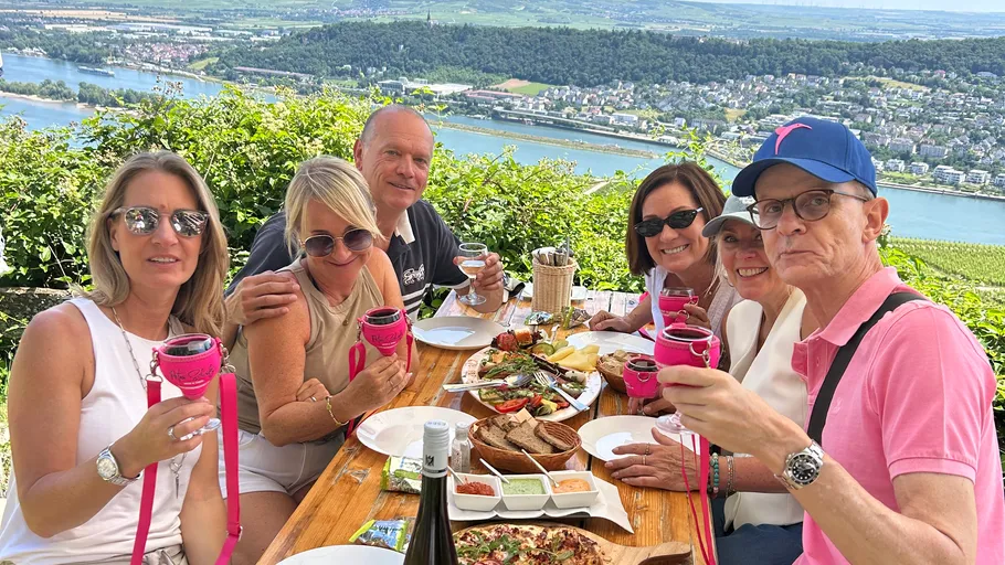 Gruppe genießt Mahlzeit mit Flussblick.