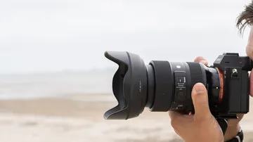 Person fotografiert Strand mit DSLR-Kamera.