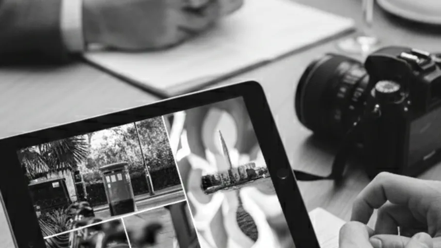 Tablet zeigt Fotos, neben Notizbuch und Kamera.