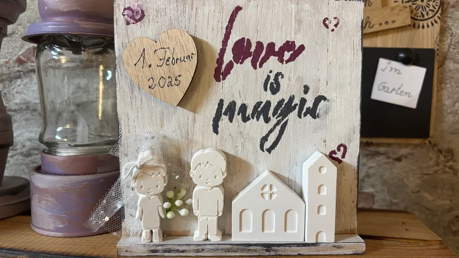 Wedding decoration with figurines and text.