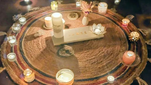 Kerzen auf rundem Teppich für Meditation arrangiert.