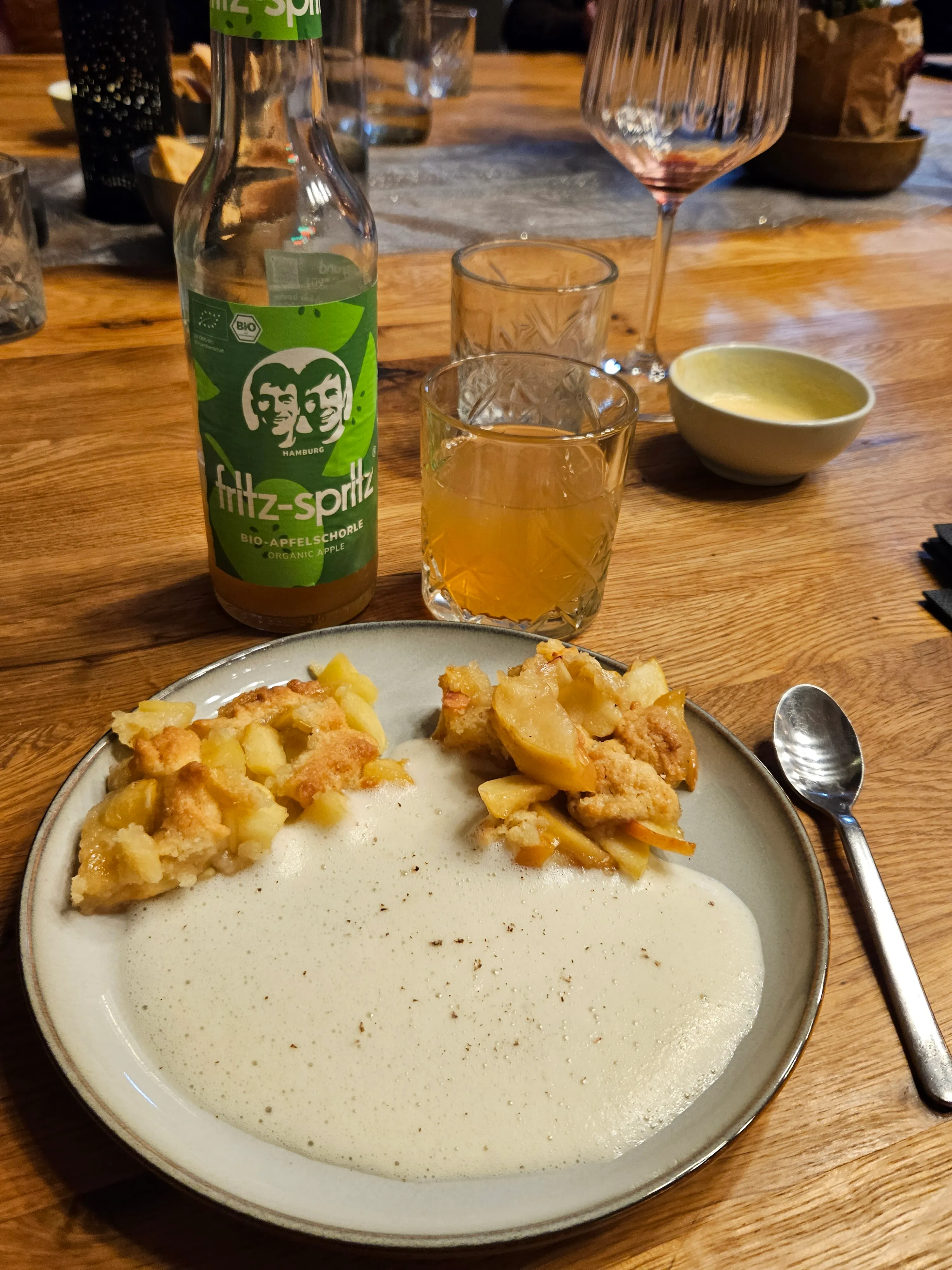 Apple dessert with vanilla sauce on wooden table.