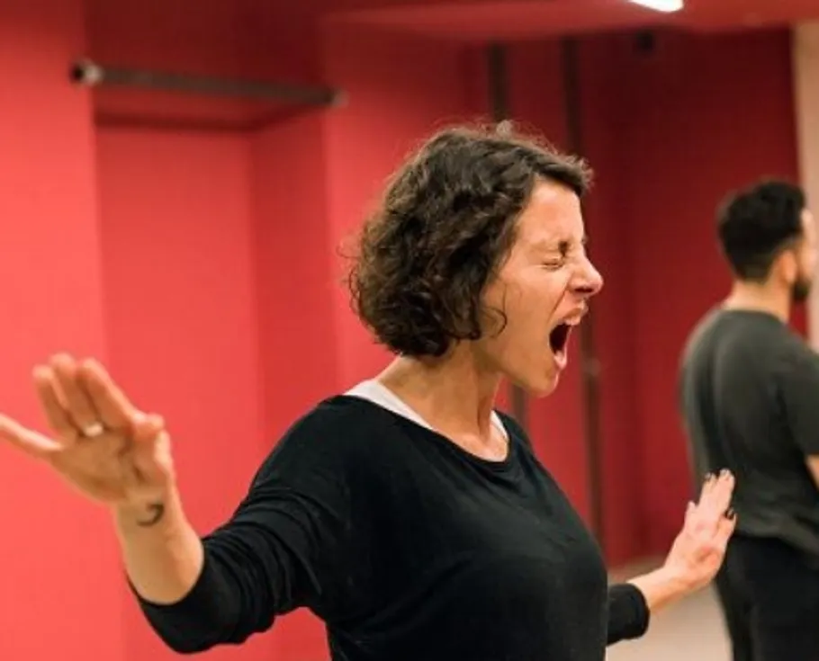Woman energetically shouting in a red room.