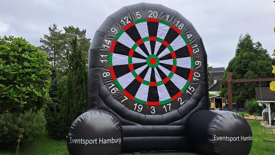 Giant inflatable dartboard in a garden.