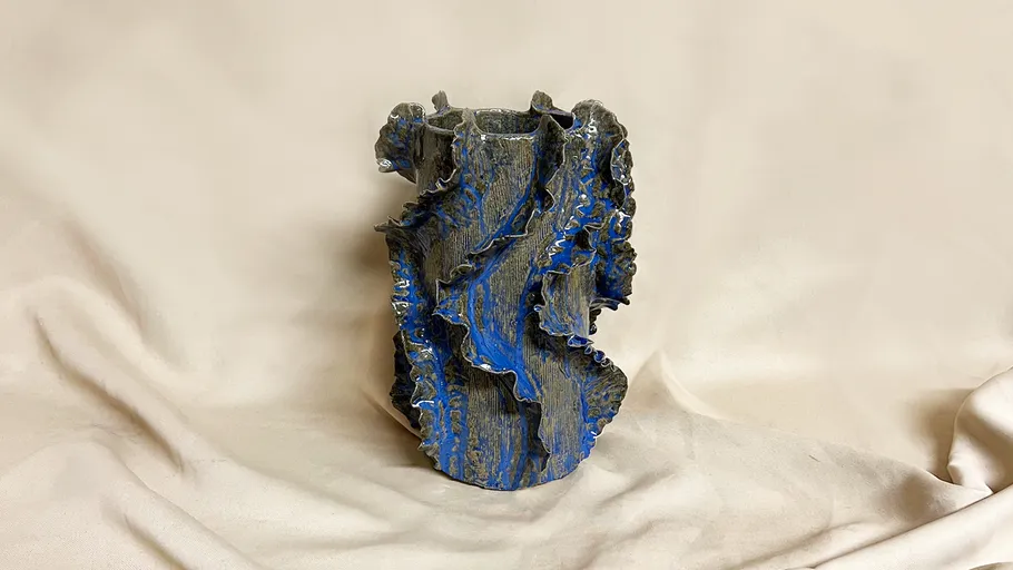 Geriffelte Keramikvase mit blauem Überzug.