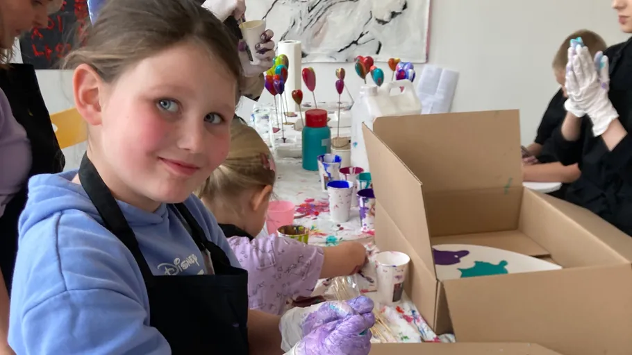 Children painting with gloves in art class.