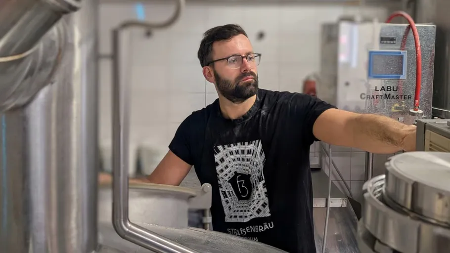 Man working in a brewery with equipment.