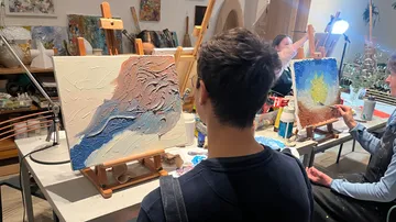 Person viewing abstract paintings in art studio.