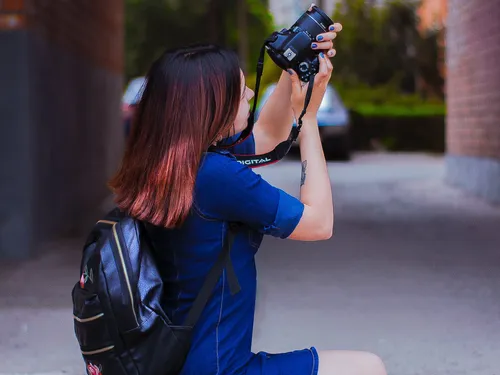 Eine Frau fotografiert in einer engen Passage mit ihrer Kamera.