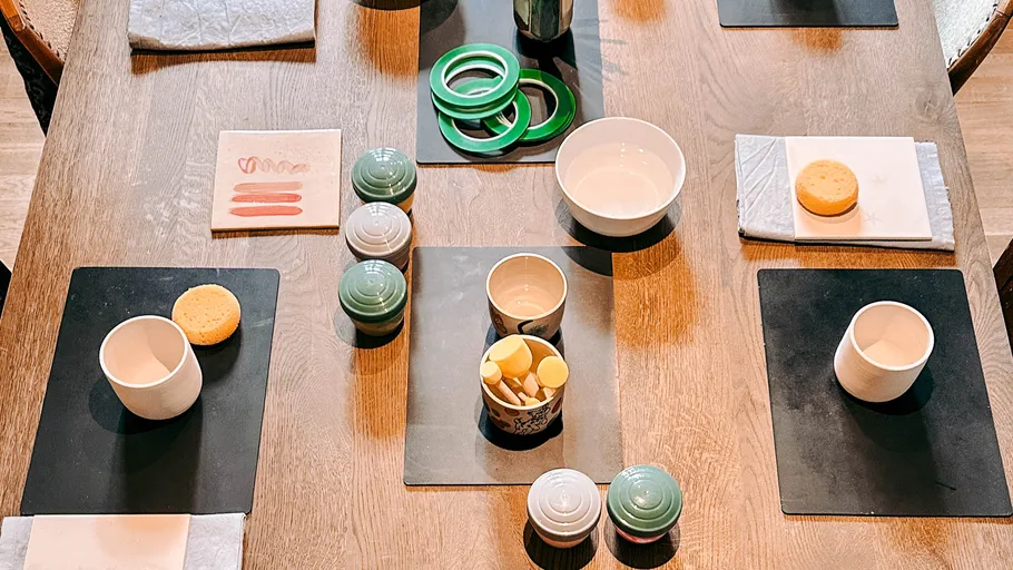 Ceramic painting setup on wooden table.