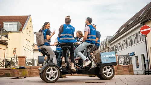 Group on a pedal-powered vehicle in a town.