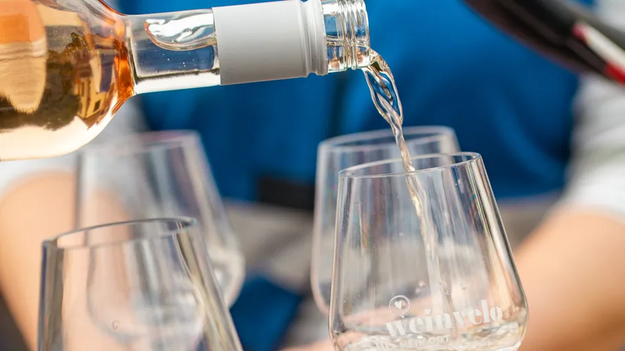 Wine being poured into glasses outdoors.