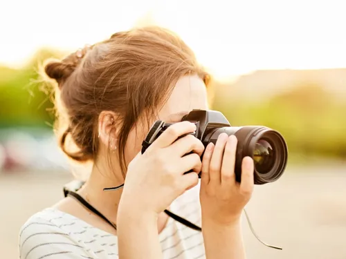 Eine Person fotografiert mit einer Kamera in der Natur.