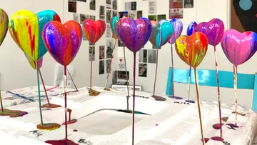 Bunte Herzskulpturen trocknen im Kunststudio.