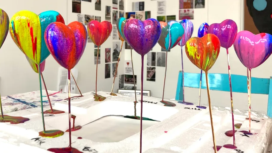 Colorful heart sculptures drying in art studio.