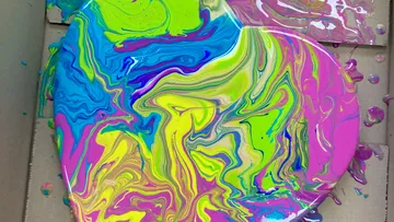 Bunte Farbswirls auf Kartonhintergrund.