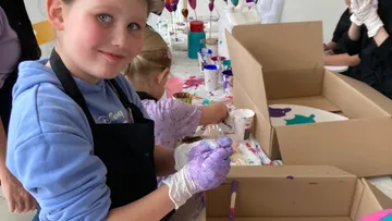 Kinder malen an einem Basteltisch.