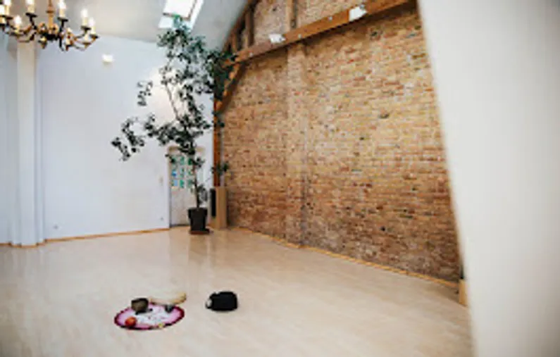 Geräumiger Raum mit Ziegelwand, Pflanzen, Holzboden.