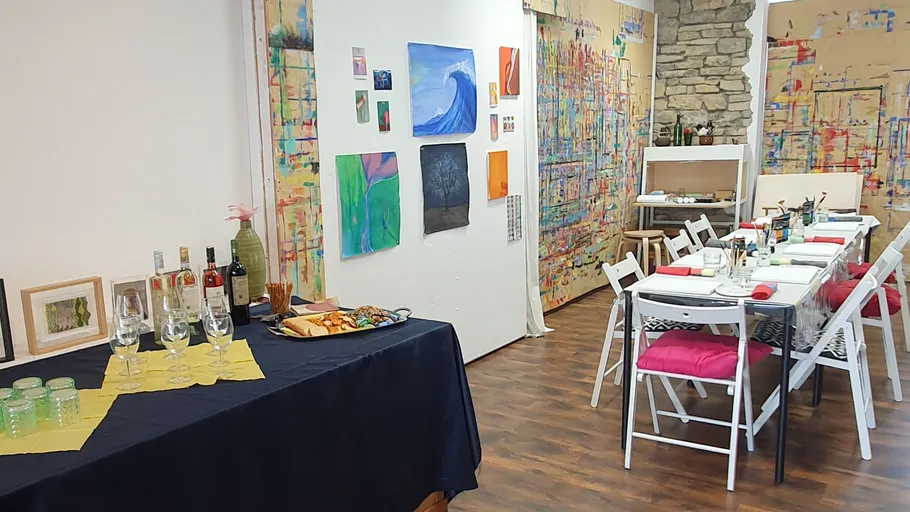 Kunststudio mit Gemälden und Tischgedeck.