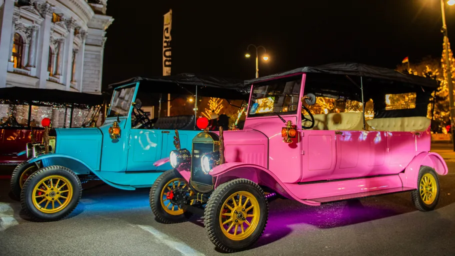 Two vintage cars parked on city street.