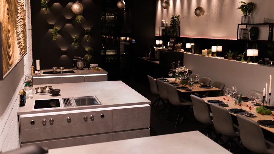 Modern kitchen with dining area, dim lighting.