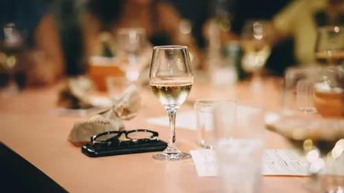 Wine glass on a table, indoor setting.