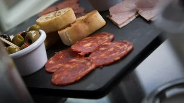 Charcuterie board with meats, olives, and bread.