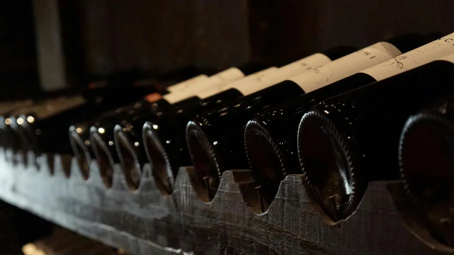 Wine bottles resting on a wooden rack.