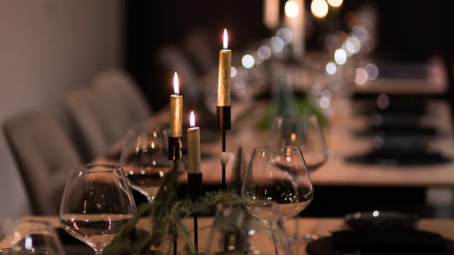 Lit candles on elegant dining table.