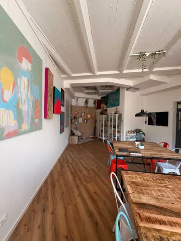 Art gallery room with colorful paintings displayed.
