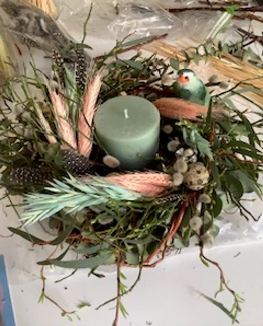 Candle in decorative bird nest centerpiece.
