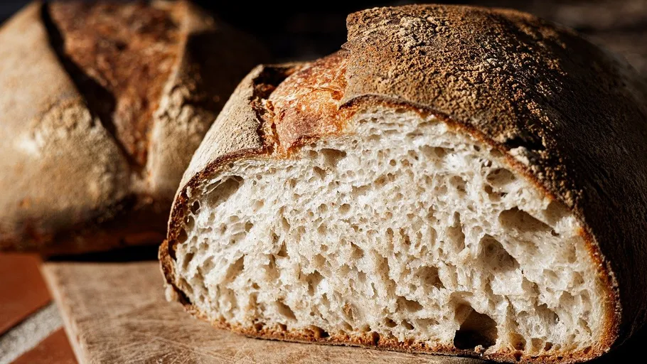 Sliced sourdough bread on wooden surface.
