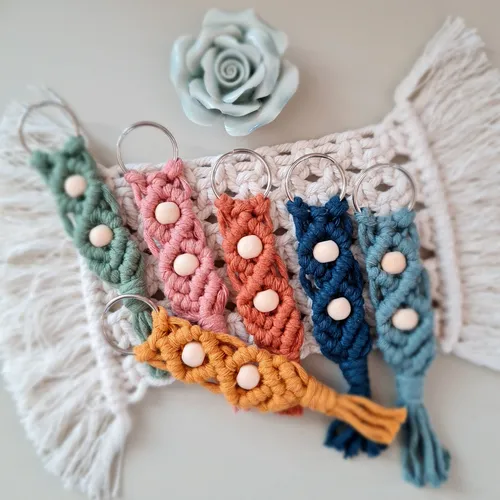 Colorful macramé keychains on crocheted surface.