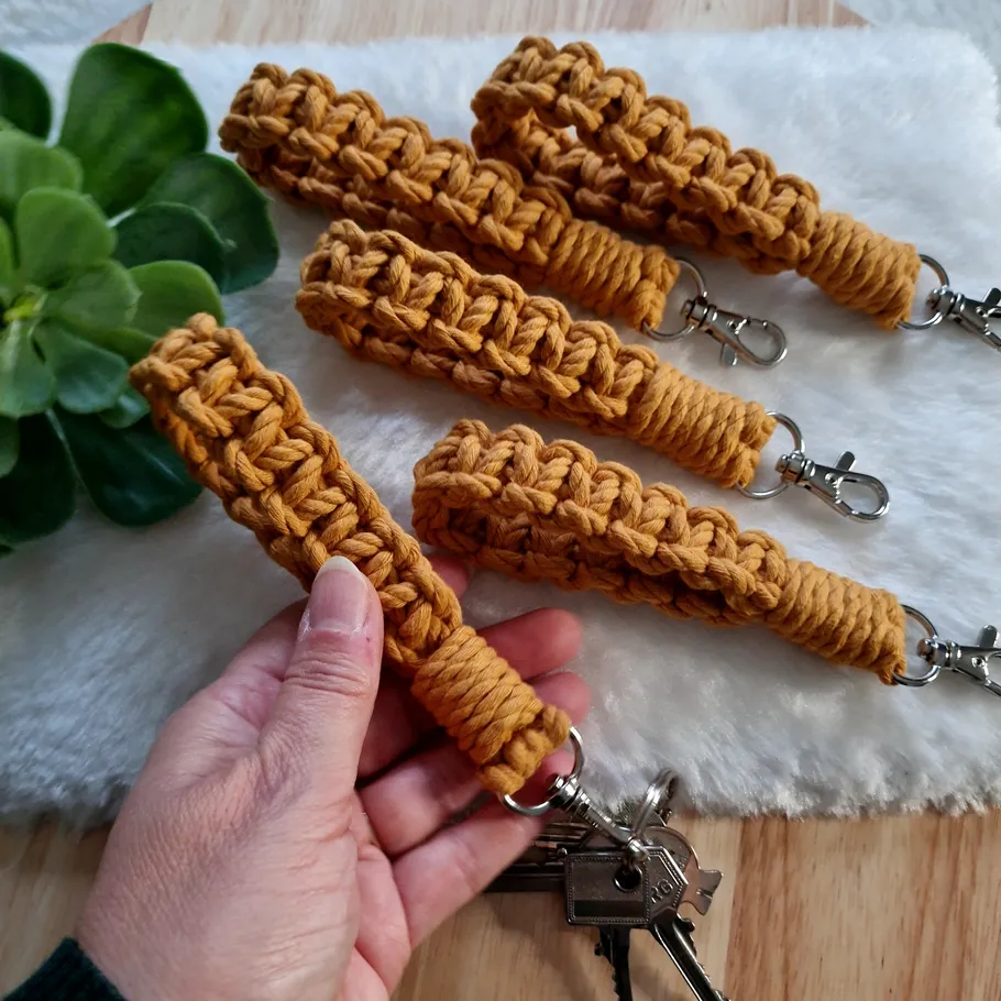 Hand holding crochet keychains on furry surface.