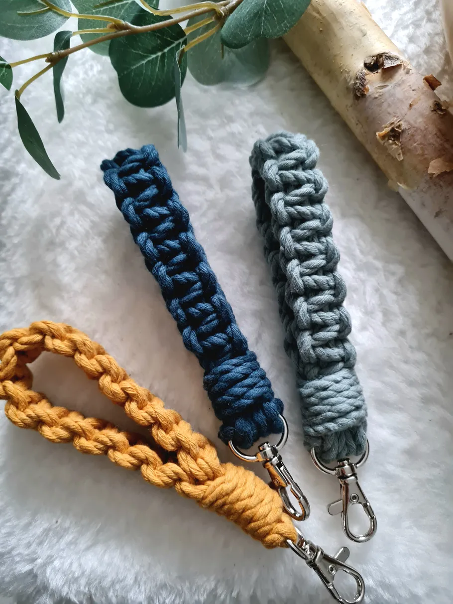 Three braided keychains on white surface.