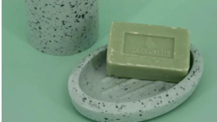 Green soap on speckled dish, cylindrical container.