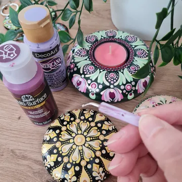 Hand painting decorative stones with paints and designs.