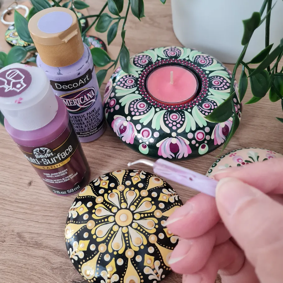 Hand painting decorative stones with paints and designs.