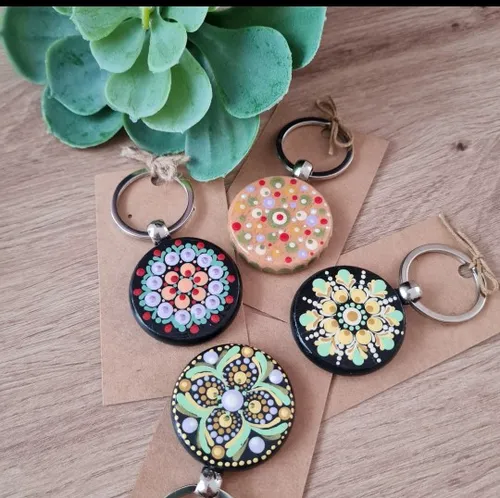 Vier bunte Mandala-Schlüsselanhänger auf Holztisch.