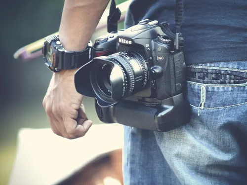 Camera hangs on a person in jeans, ready to take pictures.