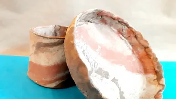 Clay vessels displayed on a blue surface.
