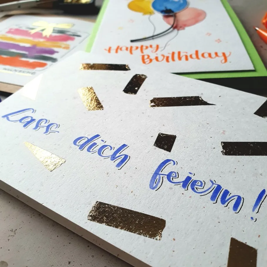 Birthday cards with colorful decorations on table.