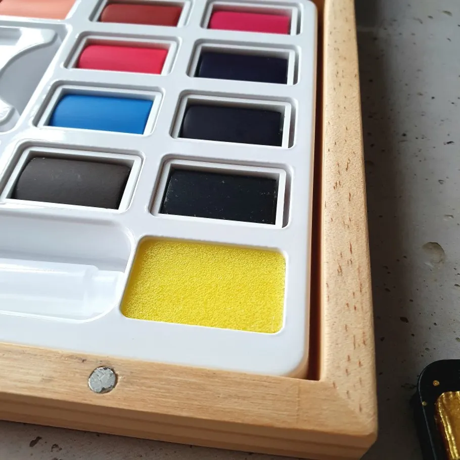 Colorful watercolor paint set on table.