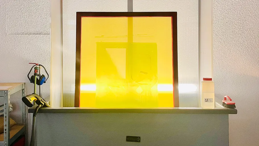 Yellow screen in workshop with tools nearby.