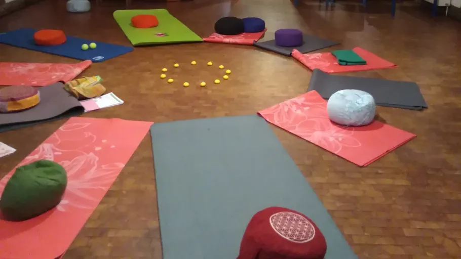 Yogamatten und Kissen im Kreis angeordnet.